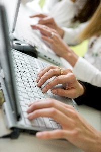 A person typing on a laptop keyboard