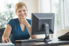 Woman using a computer to upload documents.