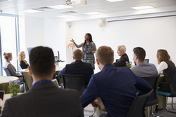 A lady talking to a room of people